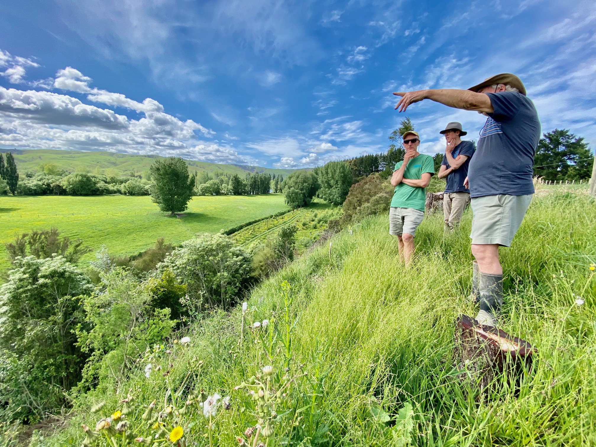 Chris Morrison, Michael Birch and Alan Wilde standing on top of a river terrace above the Ruamahanga River on Alan’s property. Alan points out areas on his farm that he has planted in trees.