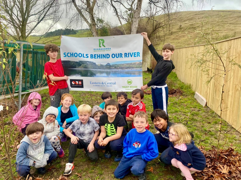 Mauriceville School pupils holding a "Schools Behind Our River" banner